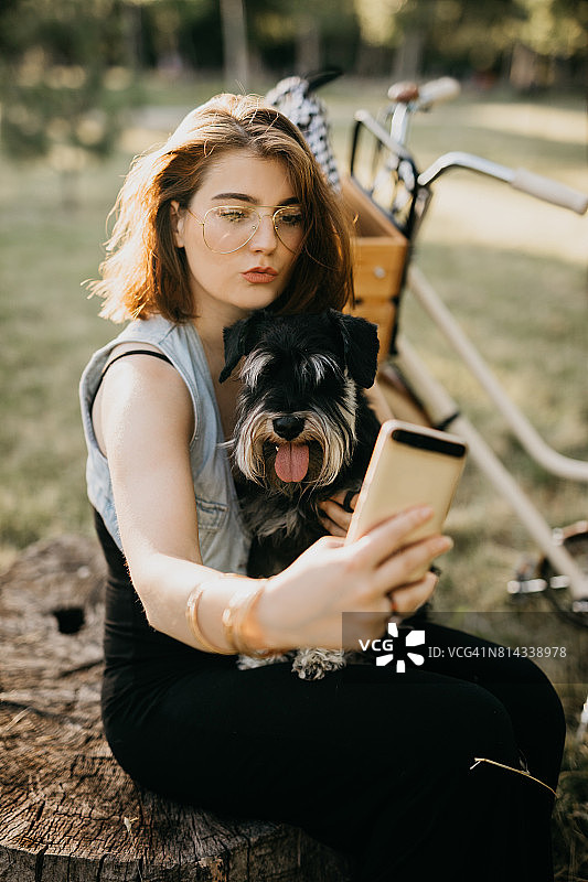 可爱的年轻女子正在和她的狗自拍图片素材