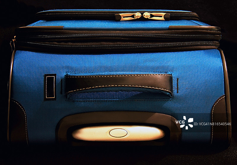 从上面看，一个黑色背景上的蓝色行李箱图片素材
