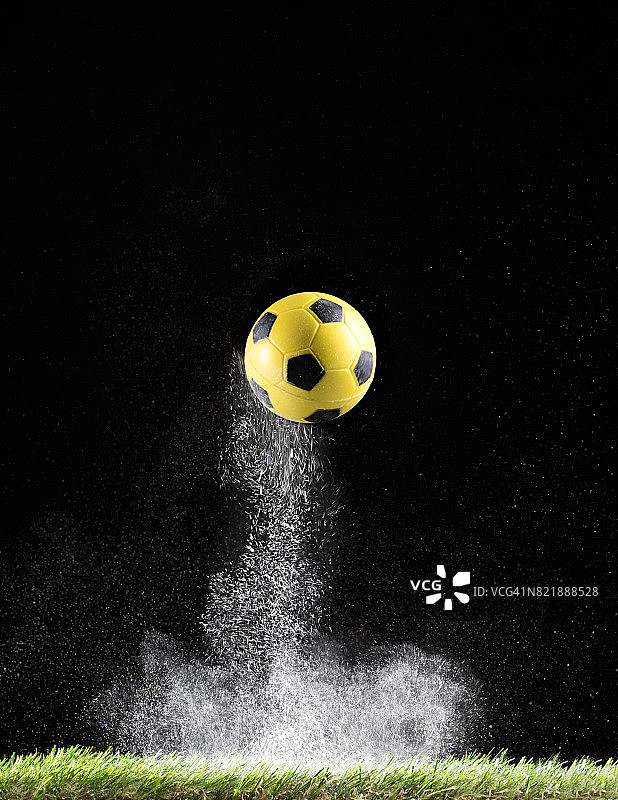 球的足球弹跳在草地表面与一团粉末的影响细节图片素材