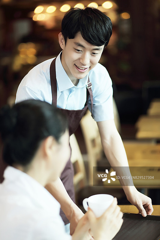 微笑的服务员在咖啡店服务咖啡图片素材