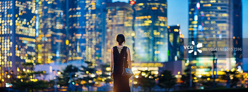 俯瞰香港城市天际线的女人的后视图图片素材