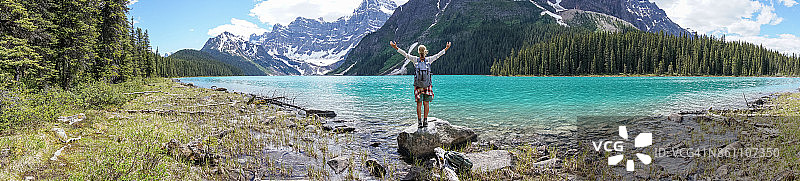 全景式的女人的手臂伸展在山和湖图片素材