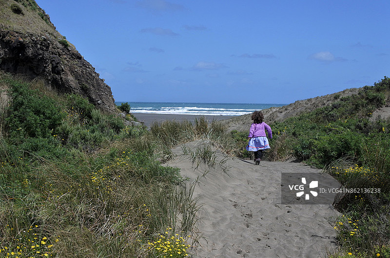 小女孩在沙丘小径上奔跑图片素材