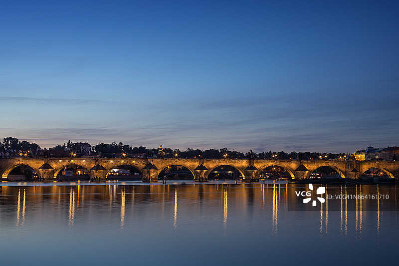 捷克共和国，布拉格，黄昏时分，查尔斯桥(卡尔鲁夫莫斯特)和它在伏尔塔瓦河上的倒影。副本的空间。图片素材