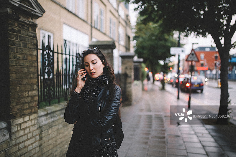 一名年轻女子在伦敦的大街上打电话图片素材
