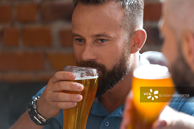 在酒吧里喝啤酒的男人，特写图片素材