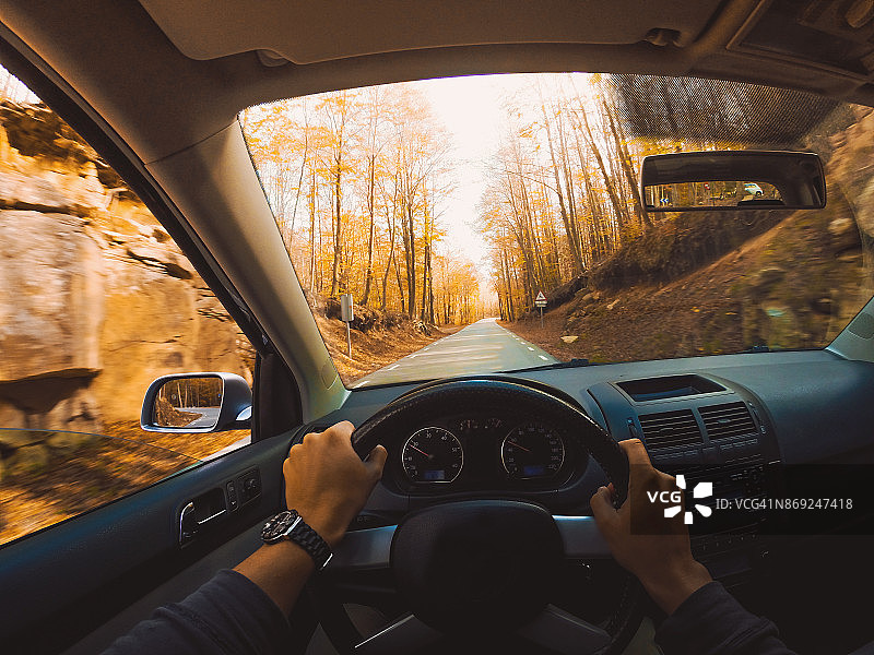 在巴塞罗那市附近的蒙特塞尼自然保护区，从个人的角度驾驶汽车在森林之间的美丽山路上的秋天的颜色。图片素材