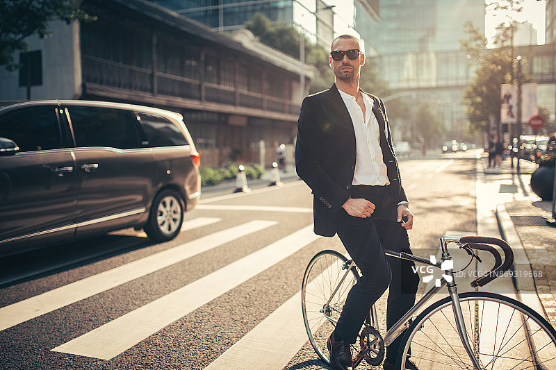 有魅力的男人骑着自行车在街上图片素材