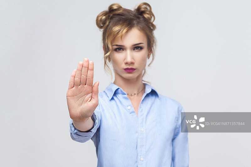 态度不好的金发女人做停止手势，手掌向外，说不，表示否认或限制。图片素材