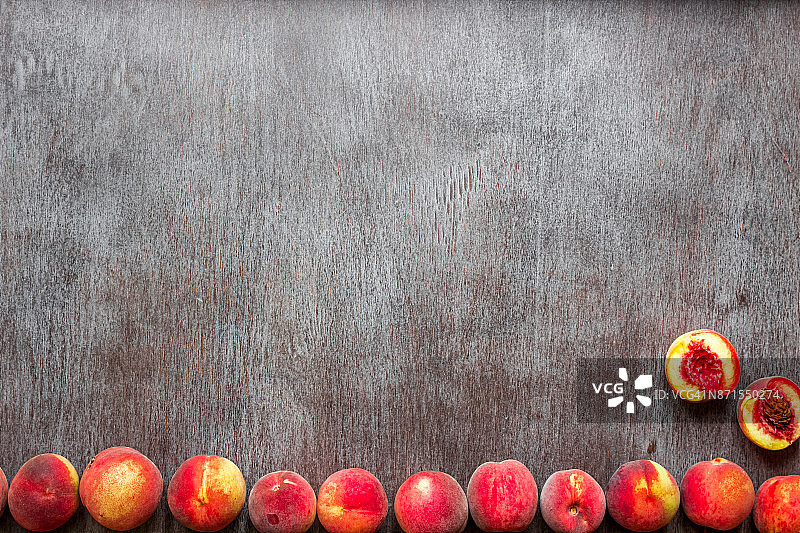 新鲜的桃子水果在深色木制的乡村背景，俯视图图片素材
