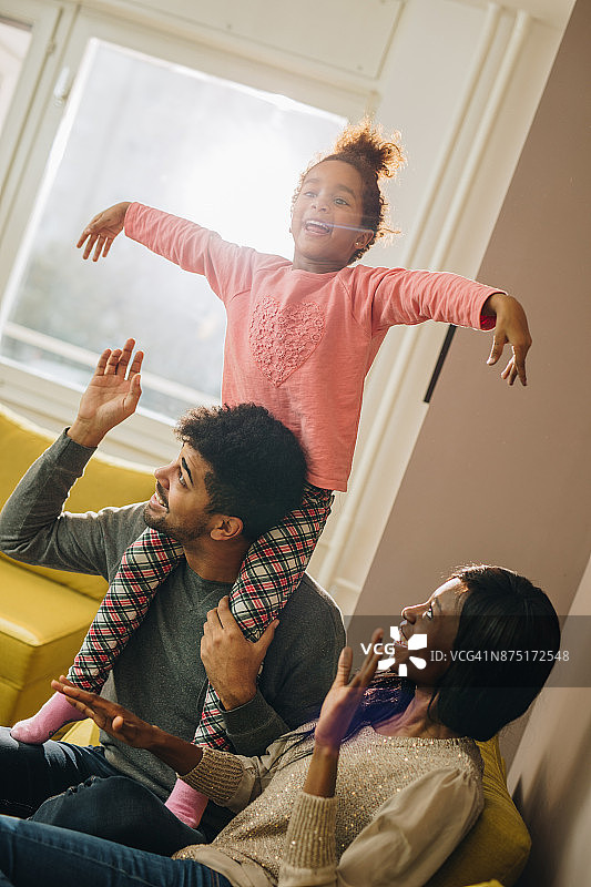 好玩的非裔美国家庭在家里玩。图片素材