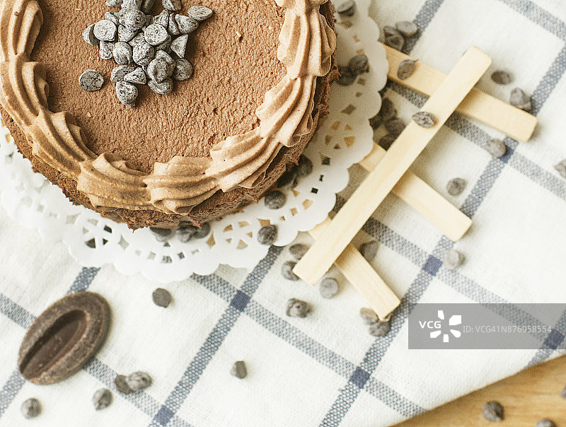 木桌上放着一块巧克力蛋糕和一些巧克力豆图片素材
