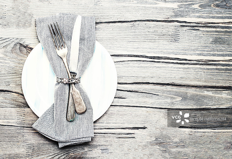 餐桌上的餐具，金属叉和刀在白色盘子与copyspace'n图片素材