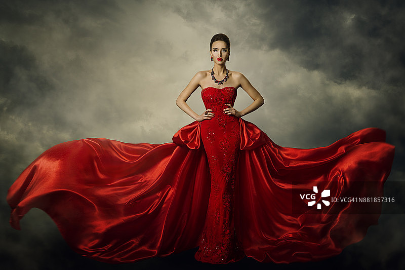 时装模特艺术礼服，优雅的女人在红色复古长袍，丝绸面料在风暴中飘扬图片素材