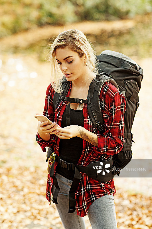 美丽年轻的金发女旅行者漫步在秋天的乡村背景在欧洲图片素材