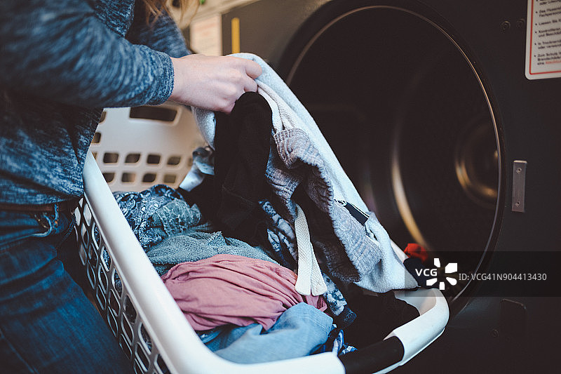 一个女人用洗衣篮洗衣服的特写图片素材
