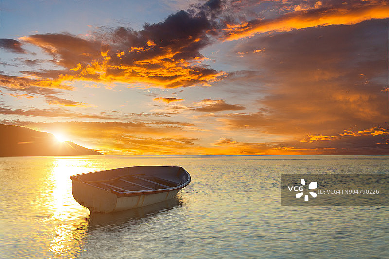 在美丽的日落背景下，热带海滩上的小船图片素材