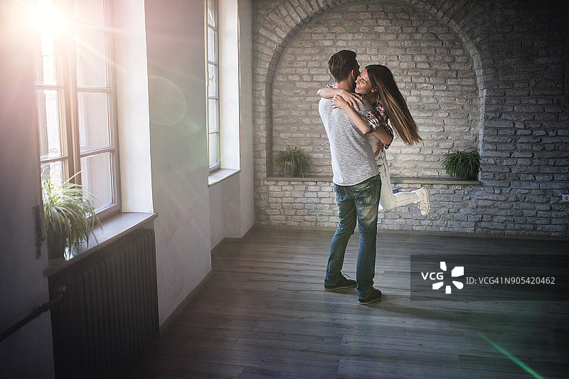 全长无忧无虑的夫妇有乐趣，而拥抱在空的公寓。图片素材