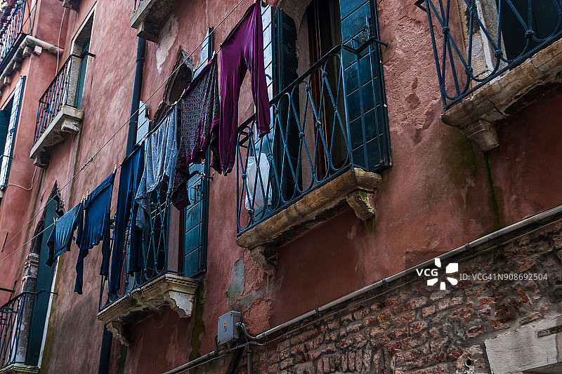 在威尼斯的一条后街，晾衣绳上的洗衣手图片素材