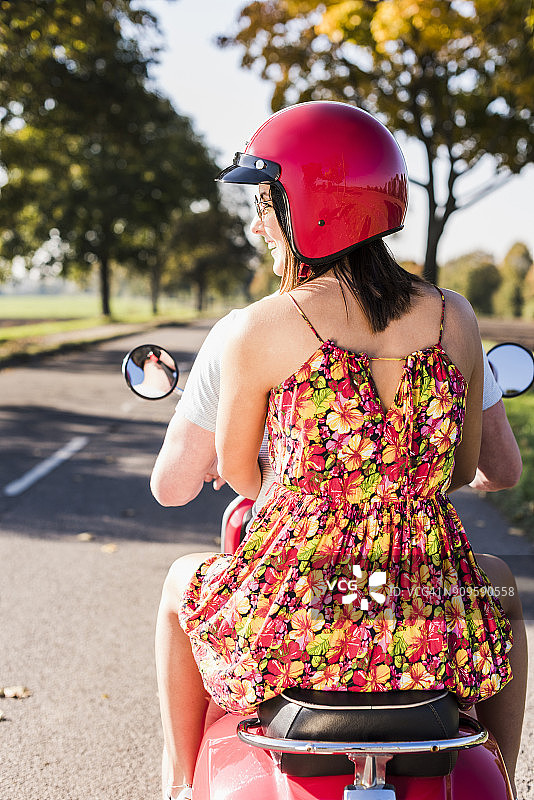 一对年轻夫妇在乡间小路上骑摩托车图片素材