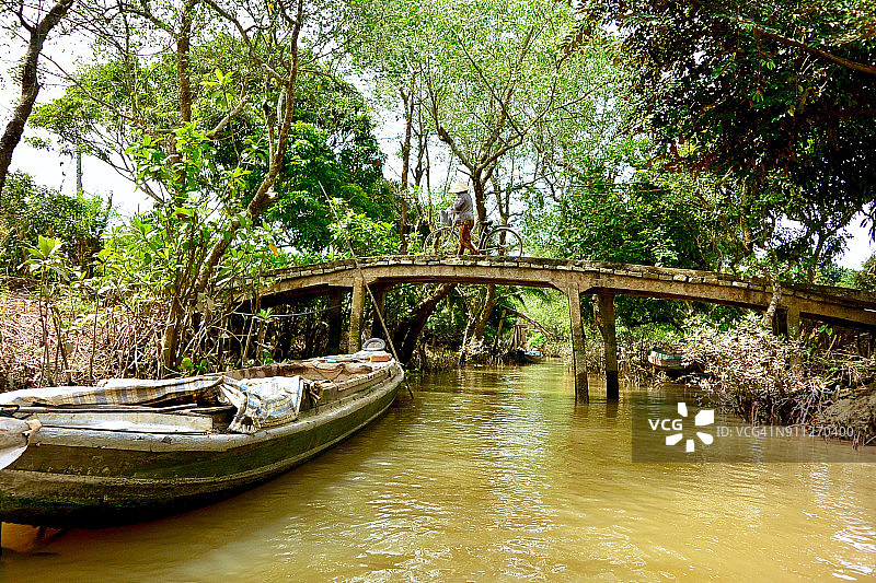 从越南湄公河三角洲运河的Boat POV上骑自行车的人图片素材