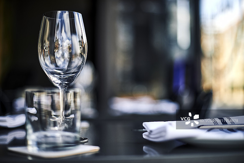 玻璃高脚杯和餐厅餐桌上的正式餐具图片素材