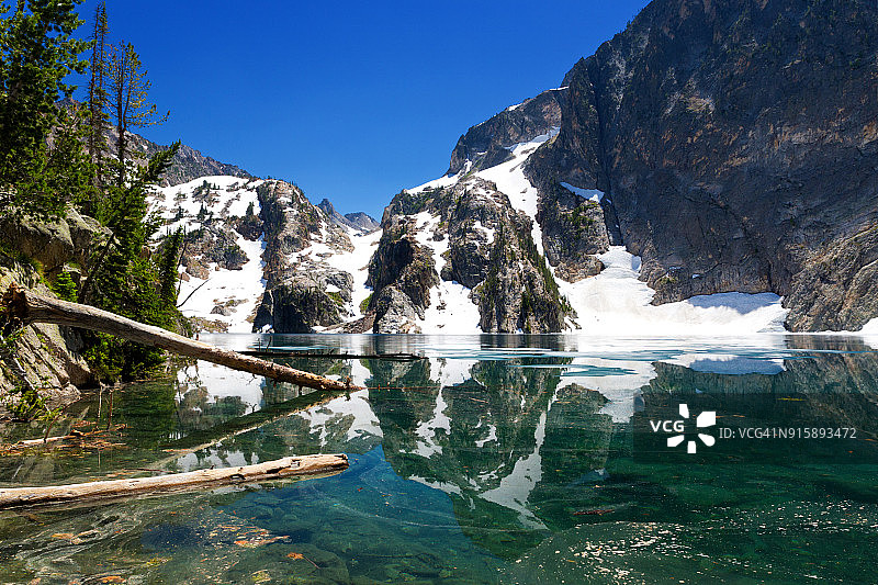 爱达荷州斯坦利，初夏时，白雪覆盖的锯齿山倒映在山羊湖上图片素材