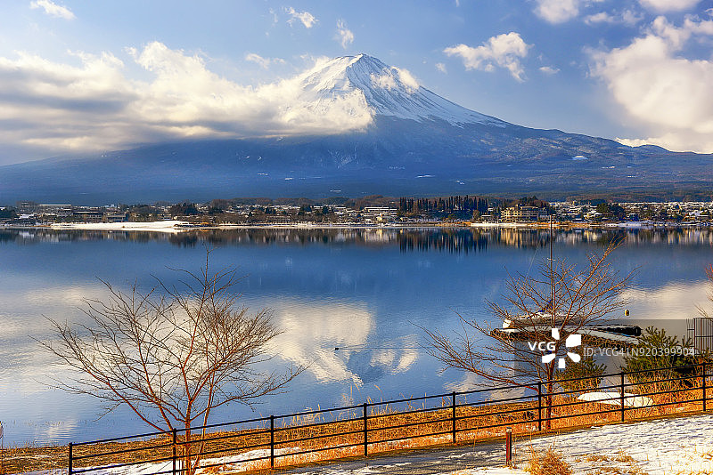 川口湖冬季多云天空中的富士山倒影与游艇码头图片素材