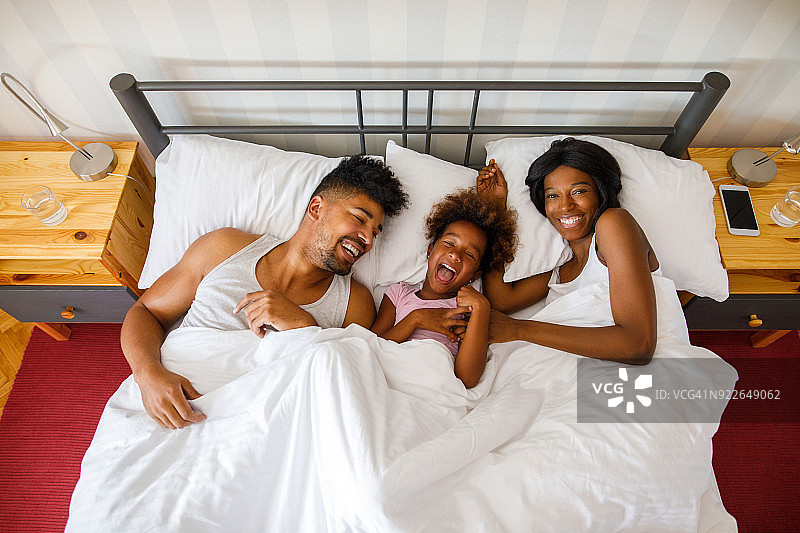 幸福的一家人躺在床上图片素材
