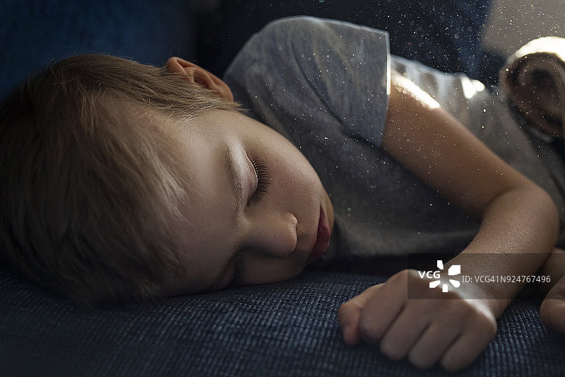 小男孩睡在满是灰尘的房间里图片素材