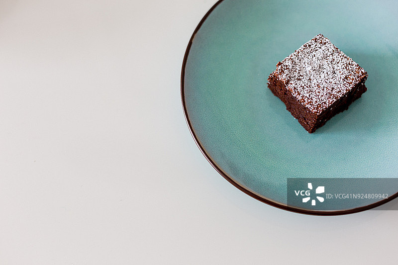在盘子里放一片糖粉巧克力蛋糕图片素材