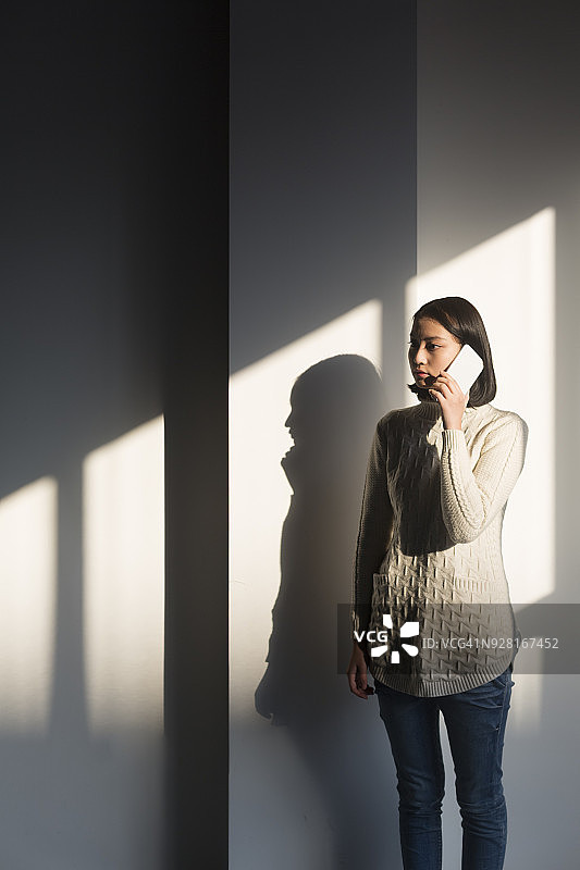 年轻女子与智能手机的影子，肖像图片素材
