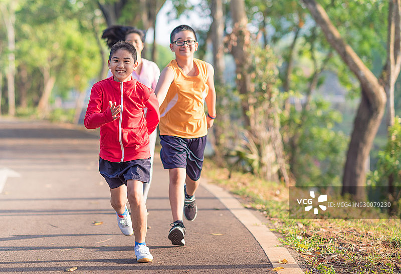 家庭运动快乐活跃的母亲和孩子在户外慢跑，在森林里跑步图片素材