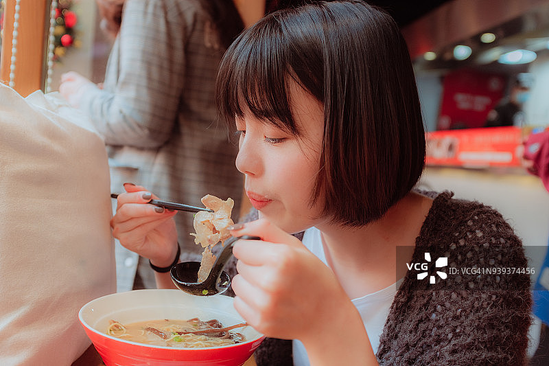 亚洲年轻女子吃面条图片素材