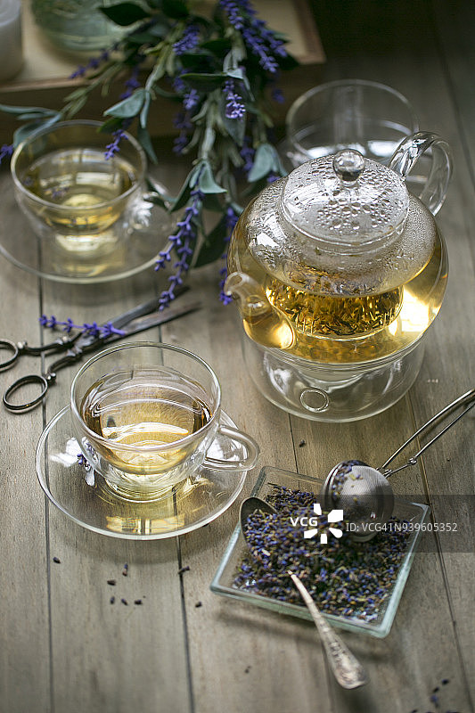 装饰杯中的薰衣草茶放在木制的桌面上。图片素材
