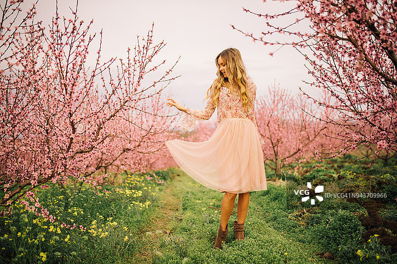 美丽的年轻女子在春天开着樱花图片素材