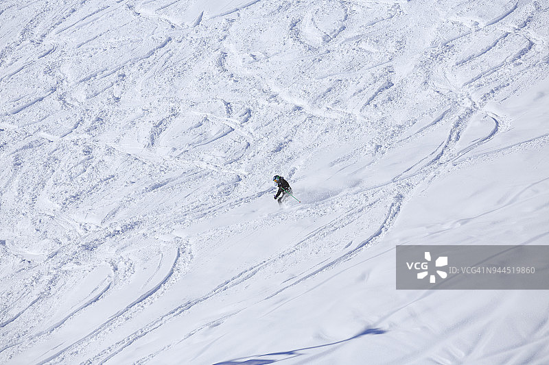 滑雪者在粉雪中滑雪。乡间滑雪，在阳光明媚的欧洲阿尔卑斯山滑雪胜地图片素材
