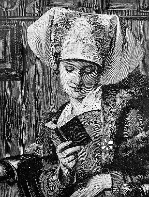 一个头上戴着民俗围巾的年轻女子的肖像。
这个女人正在看一本有趣的书图片素材