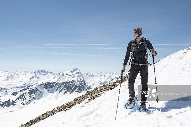 一个登山者在白雪覆盖的山谷中行走图片素材