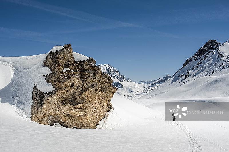 一个登山者正在探索覆盖着白雪的雄伟山谷图片素材