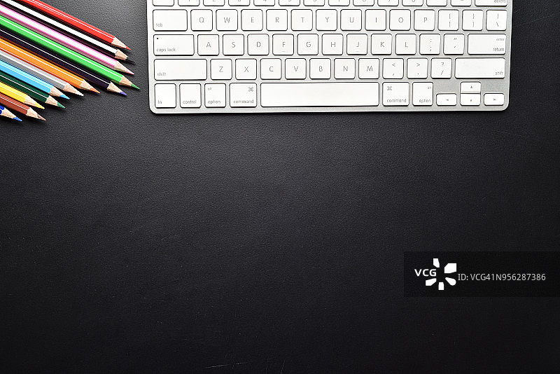 无缝彩色铅笔与电脑键盘上的黑色办公桌子桌子顶视图复制空间图片素材