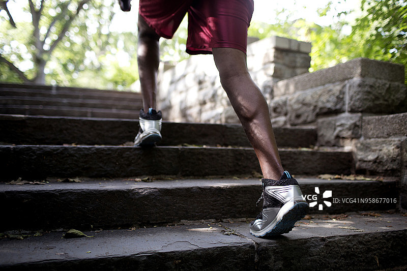 一个男人在公园的台阶上跑步图片素材