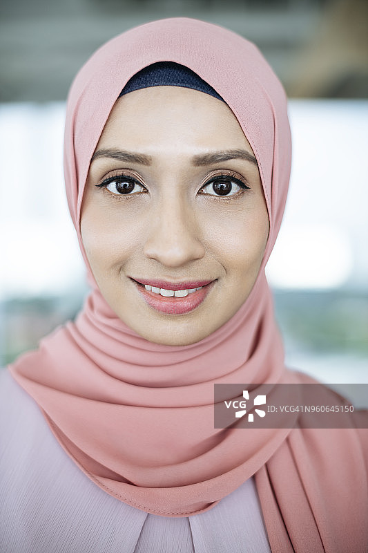 一名年轻的马来西亚妇女戴着粉红色的头巾图片素材