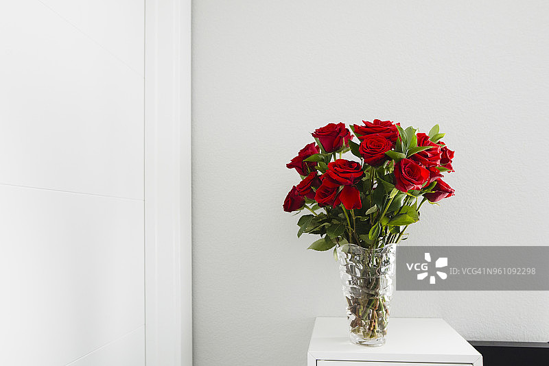 家里墙上桌子上花瓶里的玫瑰特写图片素材