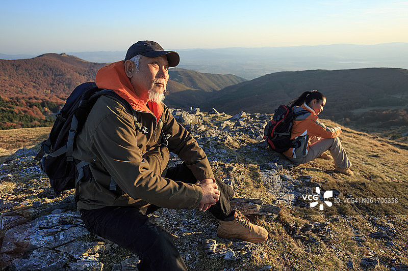 一对徒步旅行者坐在山顶休息图片素材