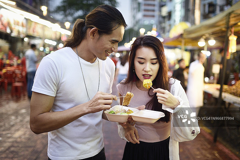 一对夫妇在夜市吃饺子图片素材