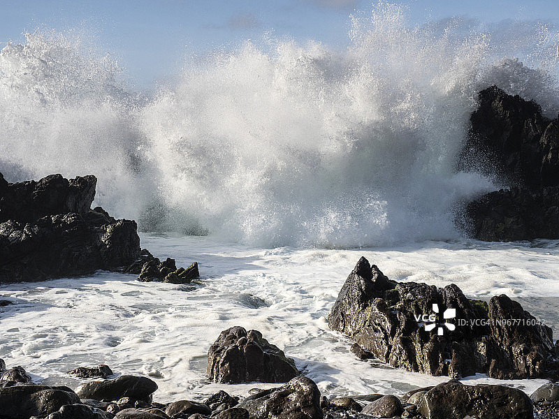 在葡萄牙亚速尔群岛的特塞拉岛，海浪的浪峰带着白色的泡沫打破在火山岩石的悬崖上。图片素材