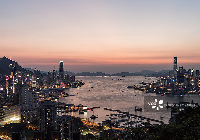 令人惊叹的日落在香港岛的天际线和九龙隔开了著名的维多利亚港在香港图片素材