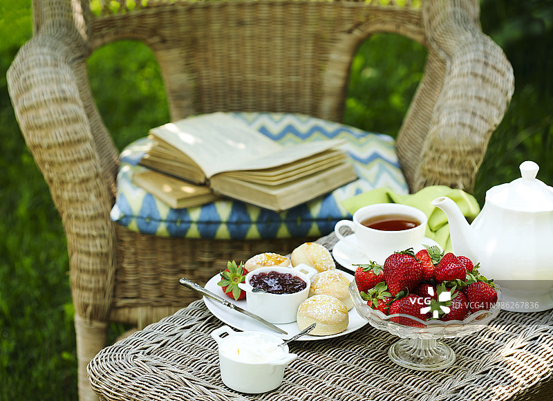 英式烤饼配果酱和鲜奶油。在花园里吃早餐图片素材