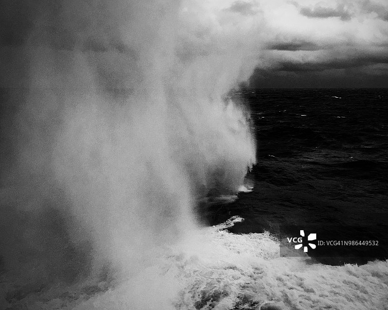巨大的波浪在浩瀚的海洋中溅起水花图片素材